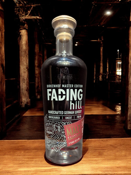 Eine Flasche Birkenhof Fading Hill Warehouse selection vor dunklem, holzigem Hintergrund