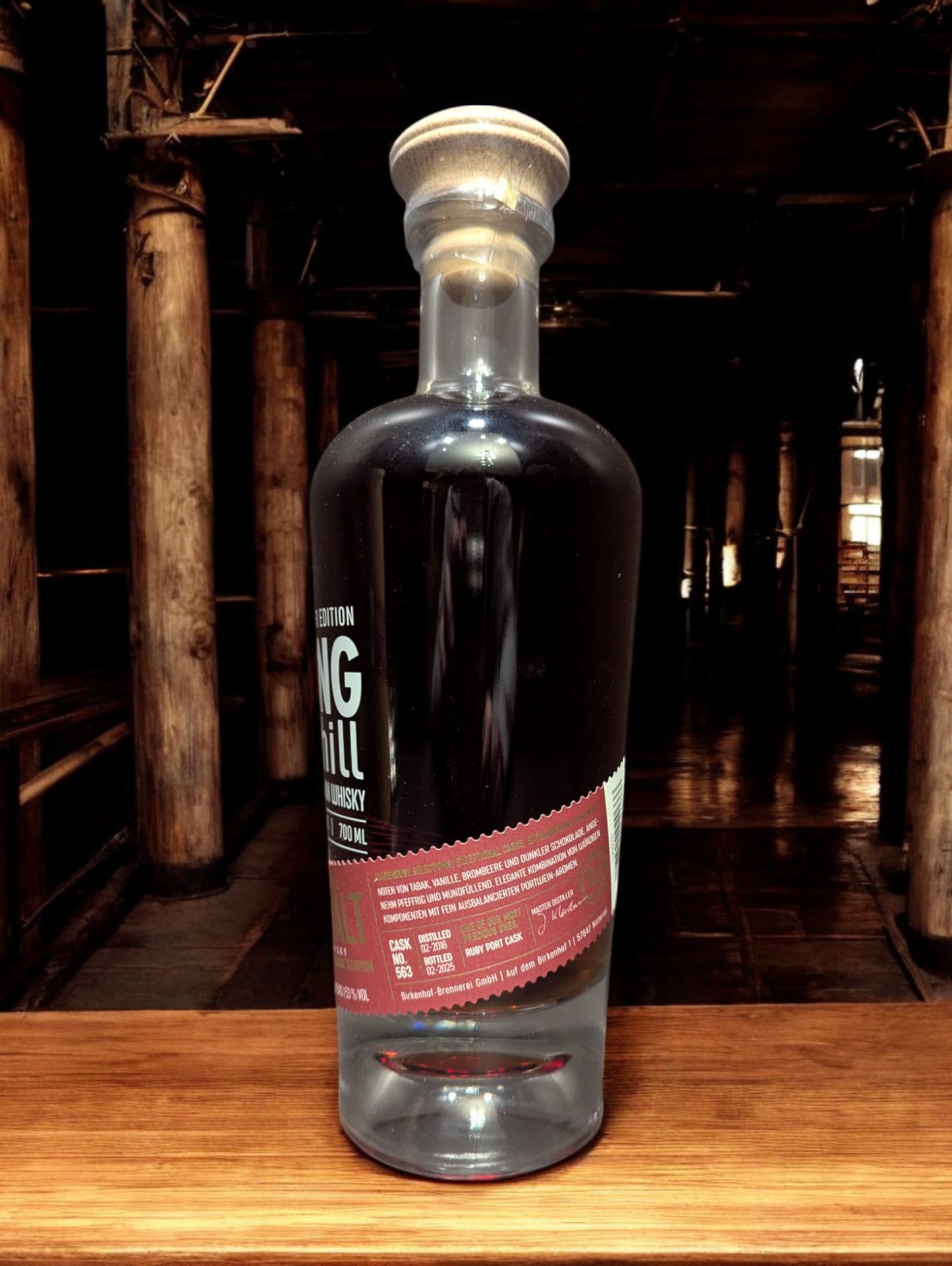 Eine Flasche Birkenhof Fading Hill Warehouse selection vor dunklem, holzigem Hintergrund