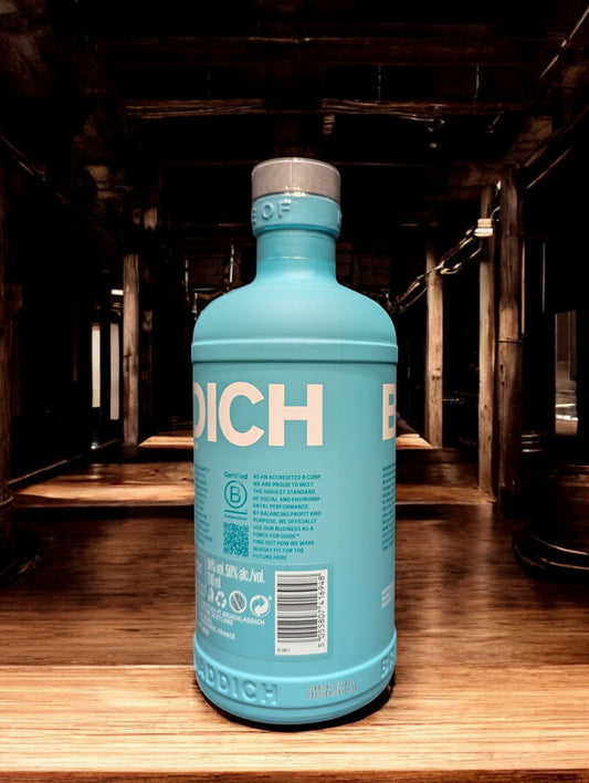 Ein Bruichladdich Classic Laddie Whisky in einer Destilleriehalle, umgeben von warmen Holzelementen, Kupferbrennblasen und Holzfässern. Die markante türkisfarbene Flasche hebt sich von der rustikalen Umgebung ab, die eine gemütliche und traditionelle Atmosphäre ausstrahlt.