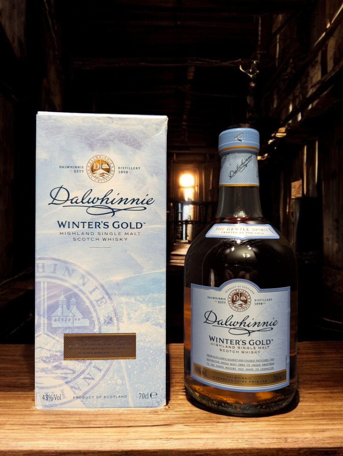 Eine Flasche Dalwhinnie Winter's Gold Whisky in einer malerischen Destilleriehalle, umgeben von Steinwänden und Holzbalken, mit einem Hauch von frostiger Kälte in der Luft. Die honigfarbene Flasche mit ihrem winterlichen Etikett vermittelt Wärme und Eleganz, während die rustikale Umgebung die Verbindung zur schottischen Berglandschaft und den eisigen Temperaturen, bei denen dieser Whisky reift, betont.