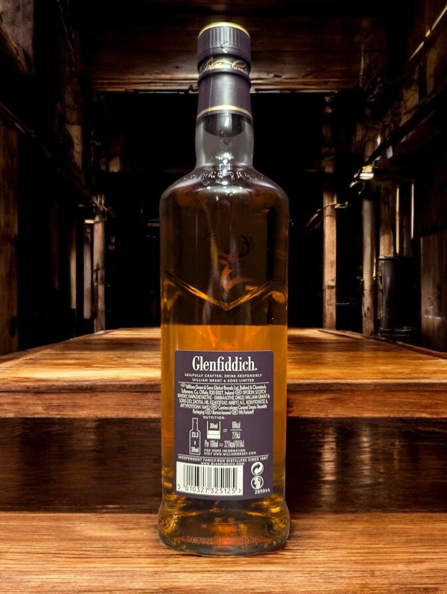 Ein Glenfiddich 15 Jahre Whisky in einer eleganten Flasche, umgeben von einer stilvollen Verpackung. Die goldene Farbe des Whiskys wird durch das Licht betont, während das Etikett die reiche Tradition und Qualität der Marke hervorhebt. Ideal präsentiert auf einem dunklen Holztisch mit einem passenden Whiskyglas, das einen Hauch von Luxus vermittelt.