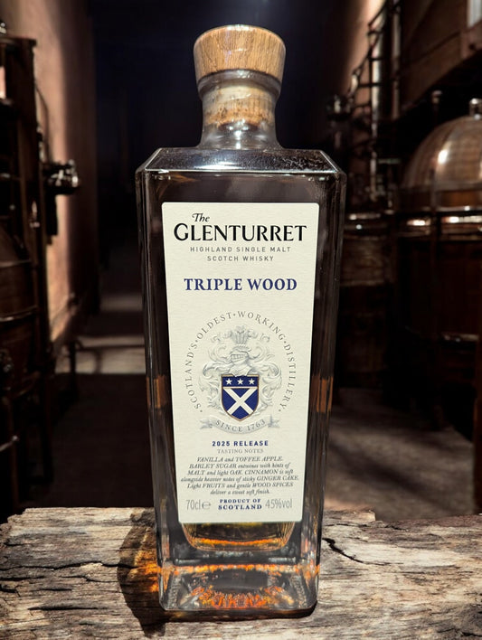 Eine Flasche Glenturret Triple Wood 2025 Whisky vor dunklem Distillenhintergrund
