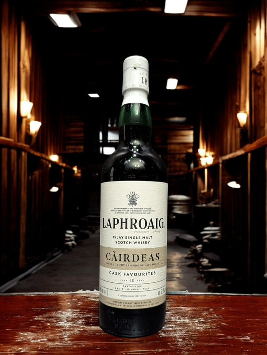 Eine Flasche Laphroaig Cairdeas 2024 Whisky auf Holztisch vor dunklem Hintergrund