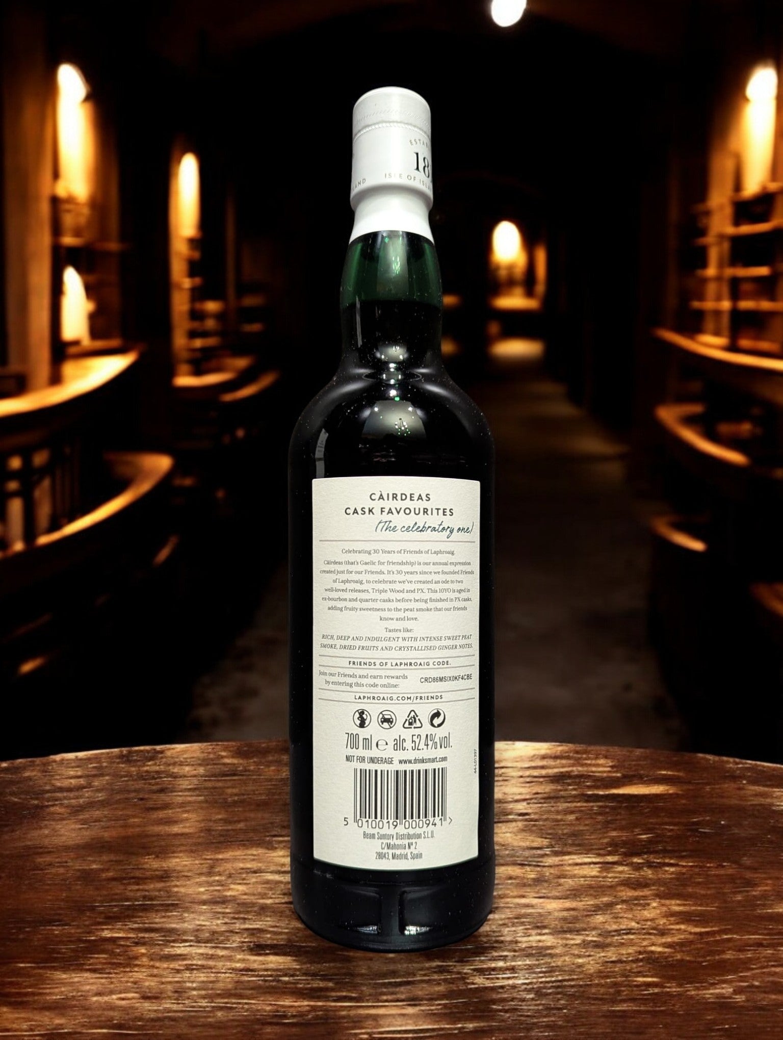 Eine Flasche Laphroaig Cairdeas 2024 Whisky auf Holztisch vor dunklem Hintergrund