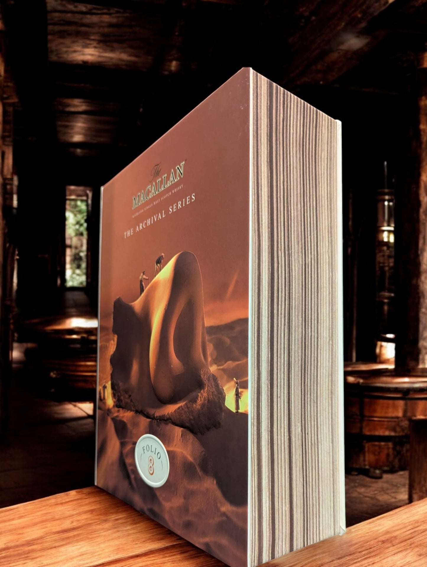 Flasche Macallan Folio 8 Single Malt Whisky vor dem atmosphärischen Hintergrund der dunklen Macallan-Destillerie, betont Eleganz und Tradition.