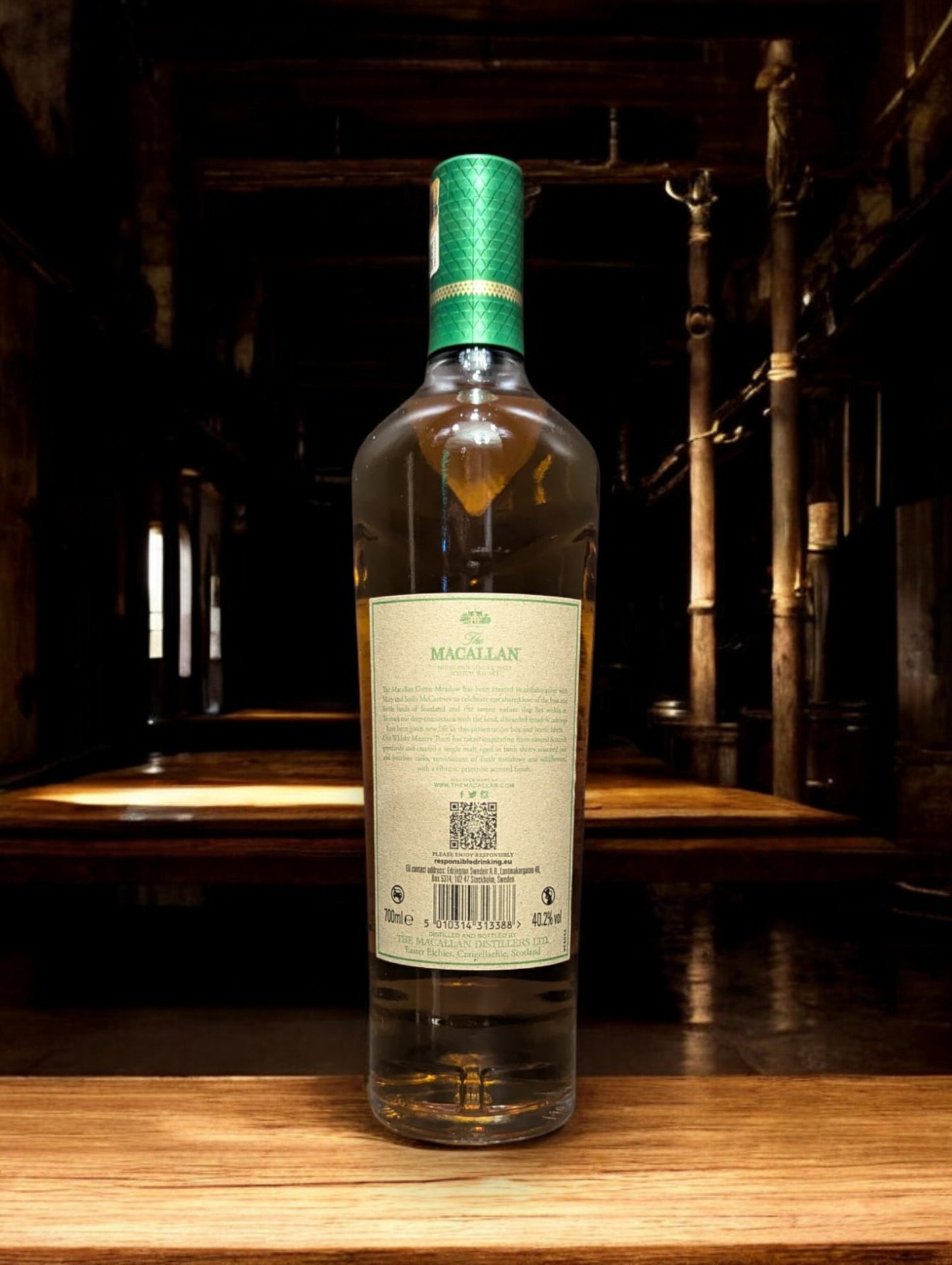 Flasche Macallan Harmony Collection Green Meadow Single Malt Whisky vor einem dunkelgrauen Hintergrund, mit einem subtilen Schimmer, der die grünlichen Akzente auf der Flasche und das hochwertige Etikett akzentuiert.