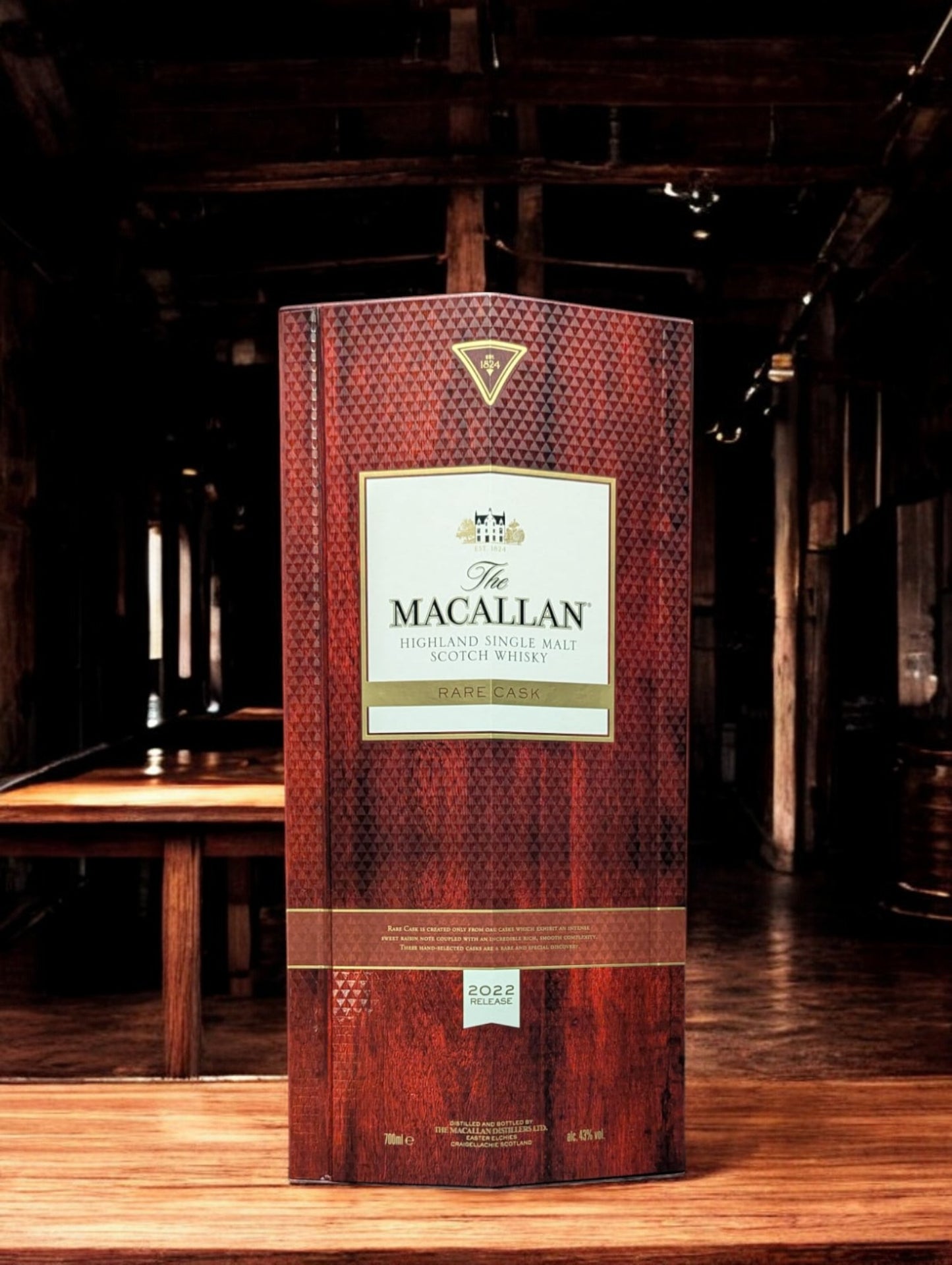 Exquisite Flasche Macallan Rare Cask 2022, sorgfältig platziert vor einem dunkelgrauen Hintergrund, was die reiche, rubinrote Farbe des Whiskys hervorhebt. Die Flasche zeichnet sich durch ihr luxuriöses Design aus, mit einem auffälligen, schwarz-goldenen Etikett, das die Seltenheit und Exklusivität dieses herausragenden Jahrgangs unterstreicht.