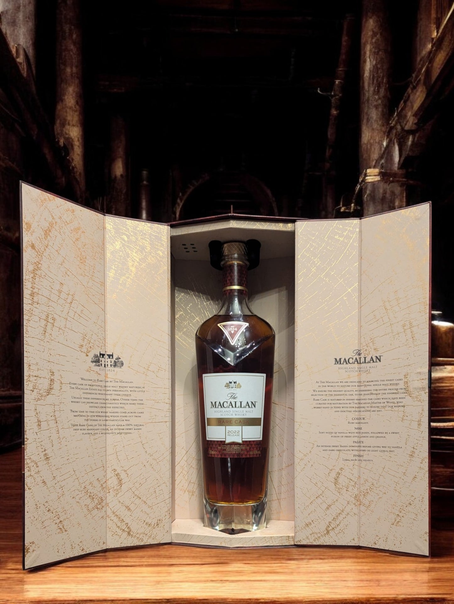 Exquisite Flasche Macallan Rare Cask 2022, sorgfältig platziert vor einem dunkelgrauen Hintergrund, was die reiche, rubinrote Farbe des Whiskys hervorhebt. Die Flasche zeichnet sich durch ihr luxuriöses Design aus, mit einem auffälligen, schwarz-goldenen Etikett, das die Seltenheit und Exklusivität dieses herausragenden Jahrgangs unterstreicht.