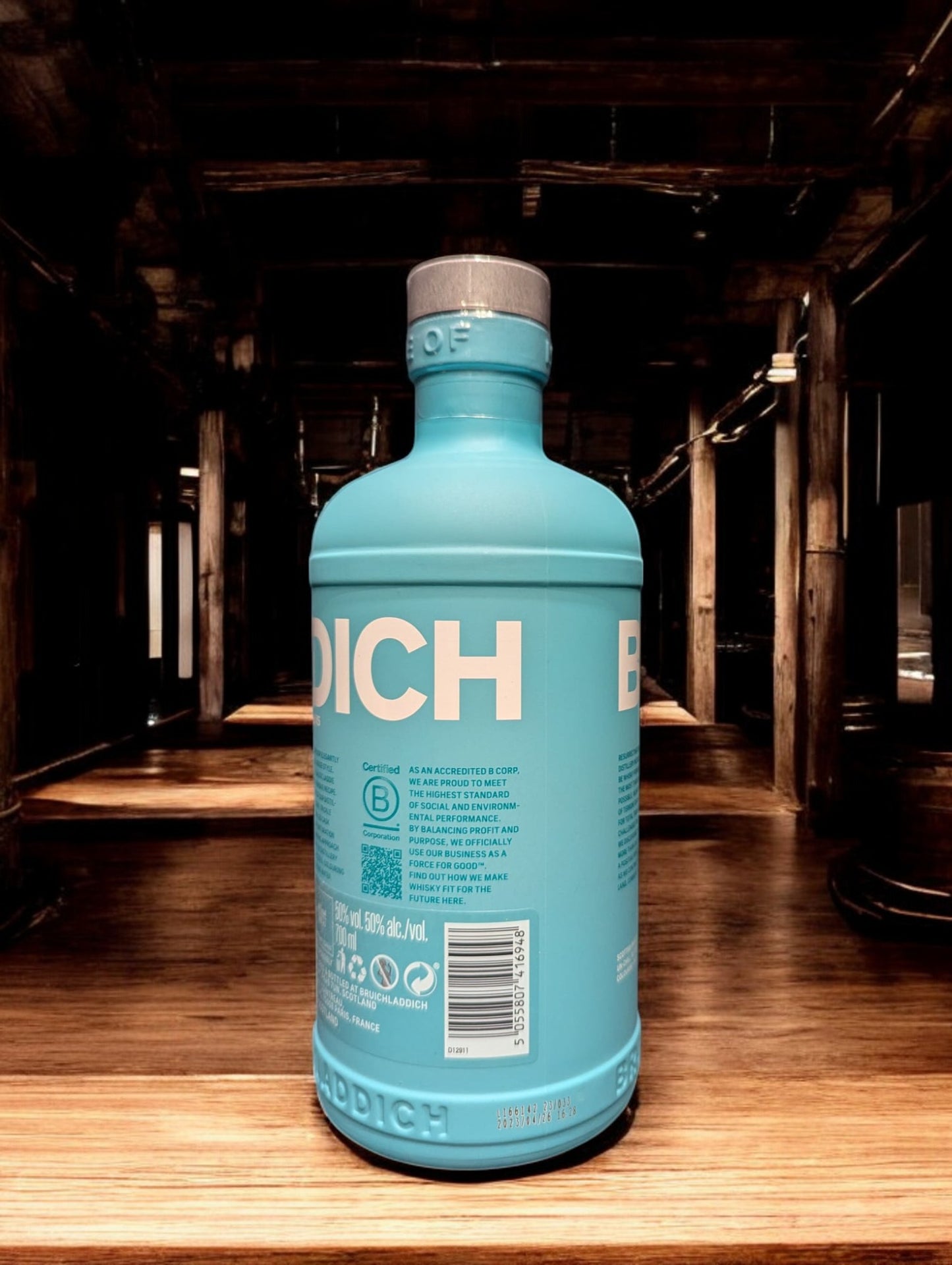 
Ein Bruichladdich Classic Laddie Whisky in einer Destilleriehalle, umgeben von warmen Holzelementen, Kupferbrennblasen und Holzfässern. Die markante türkisfarbene Flasche hebt sich von der rustikalen Umgebung ab, die eine gemütliche und traditionelle Atmosphäre ausstrahlt.