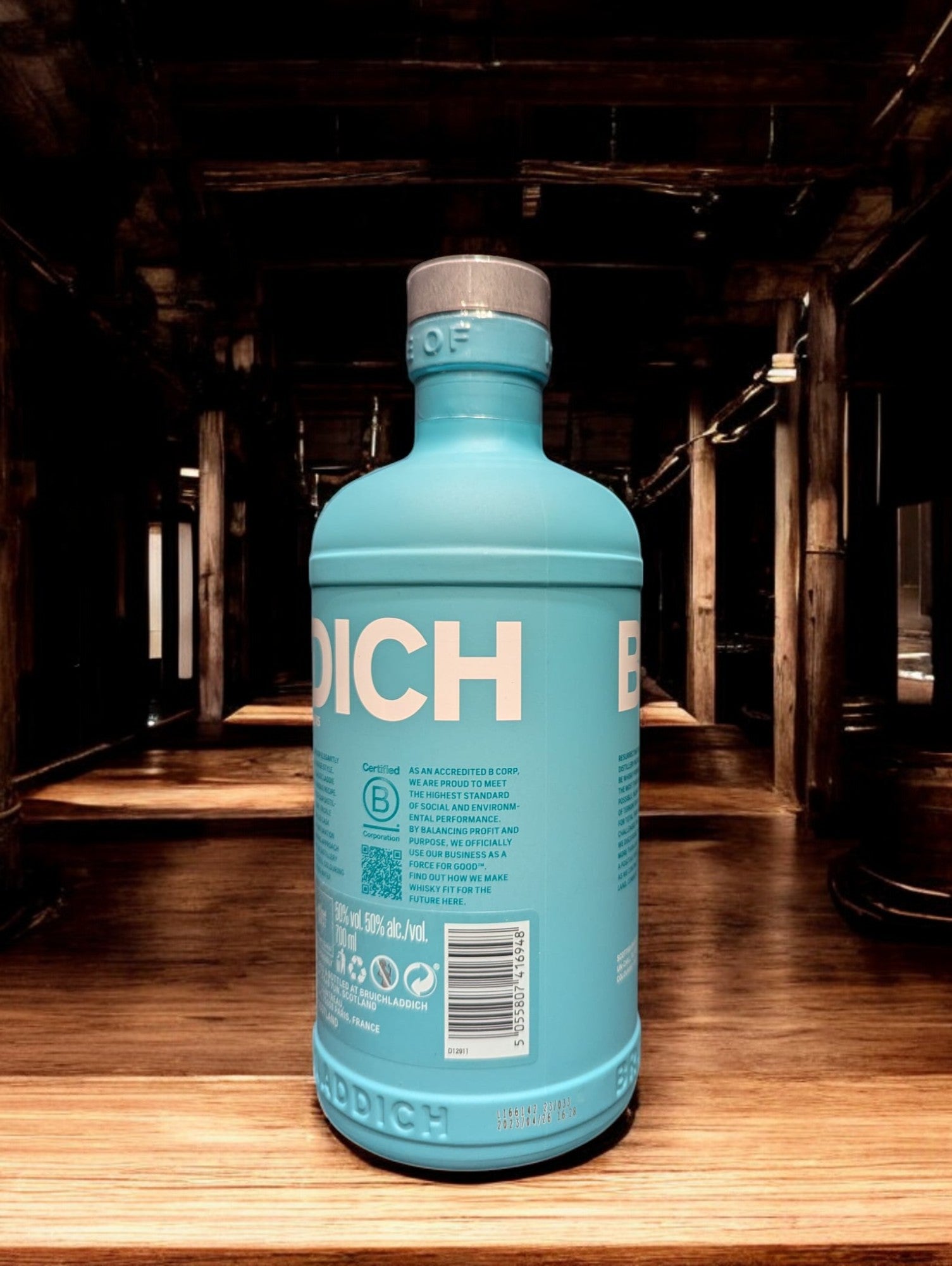
Ein Bruichladdich Classic Laddie Whisky in einer Destilleriehalle, umgeben von warmen Holzelementen, Kupferbrennblasen und Holzfässern. Die markante türkisfarbene Flasche hebt sich von der rustikalen Umgebung ab, die eine gemütliche und traditionelle Atmosphäre ausstrahlt.