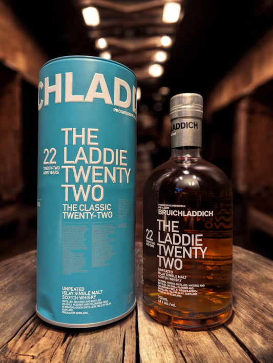 Flasche Bruichladdich 22 mit Tube vor dunklem, holzigen Hintergrund
