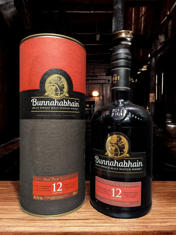 Flasche Bunnahabhain 12 Jahre Single Malt Scotch Whisky, präsentiert vor einem dunklen Hintergrund, die das sanfte Bernstein des Whiskys hervorhebt und das traditionelle, maritime Design des Etiketts mit den charakteristischen maritimen Elementen und der klaren Schrift akzentuiert.