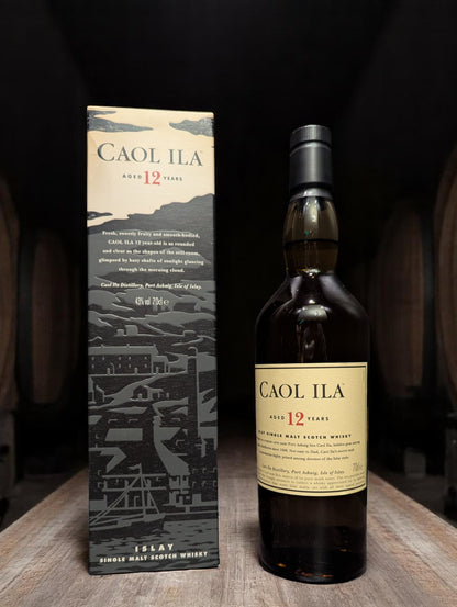 Flasche Caol Ila 12 Years Single Malt Whisky vor dunkler Destillerie-Kulisse.