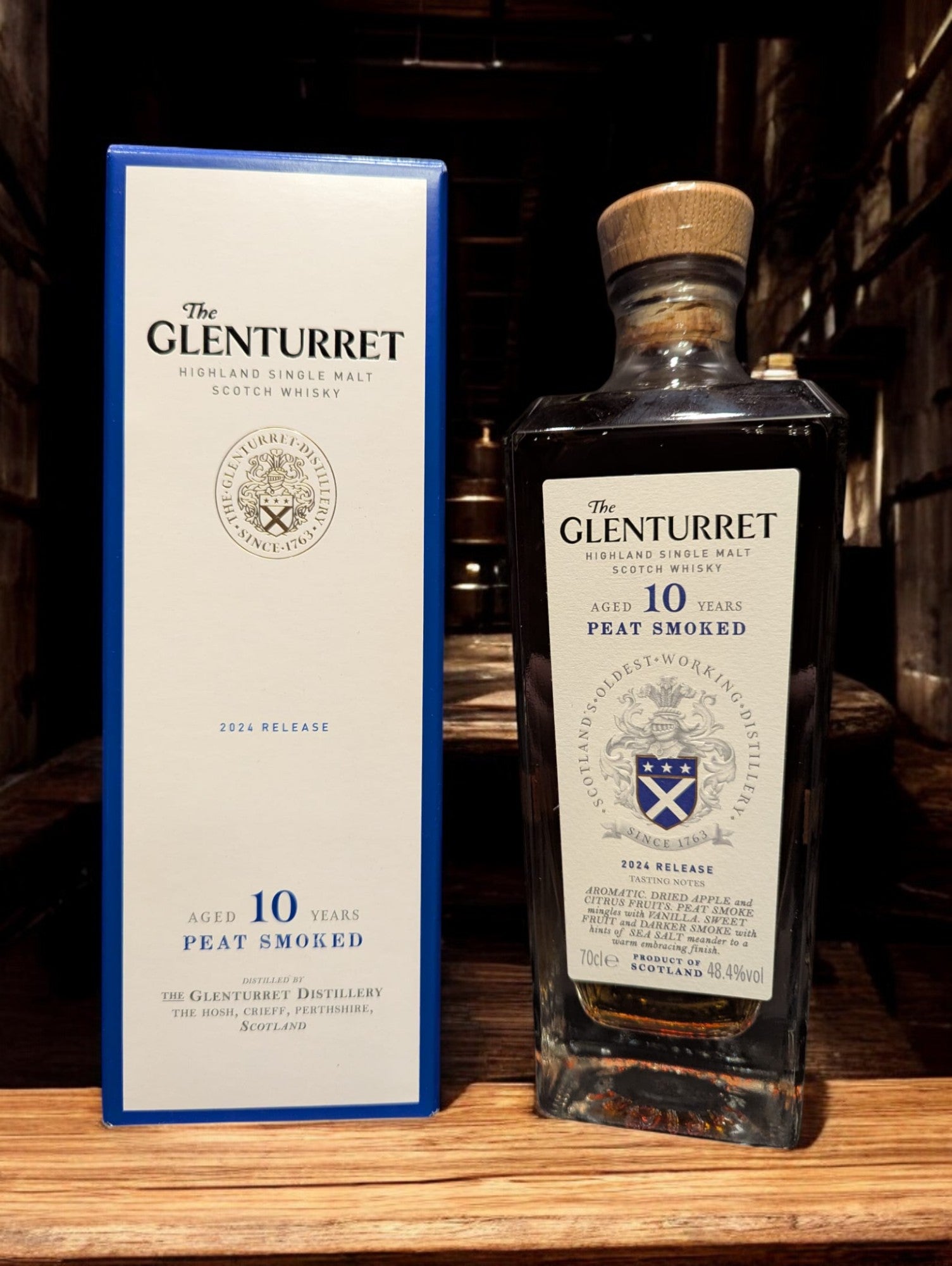 Flasche Glenturret 10 yo Peat Smoked Whisky vor dunklem, industriellem Hintergrund, betonend die rauchige Eleganz des Malts.