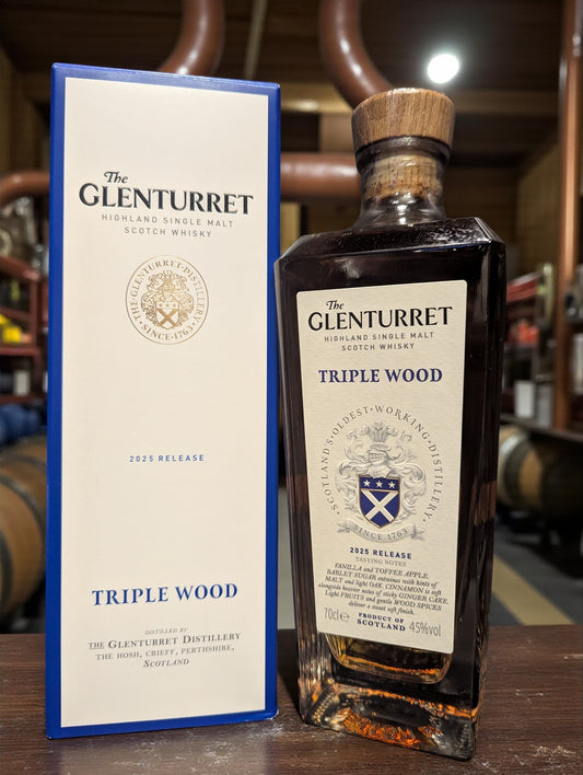 Eine Flasche Glenturret Triple Wood 2025 Whisky vor dunklem Distillenhintergrund