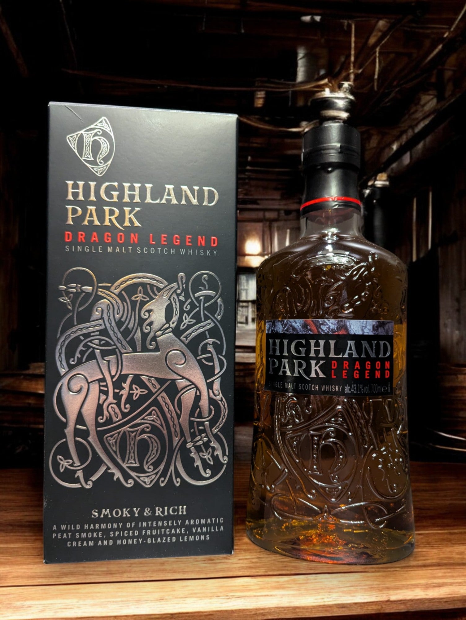 Eine Flasche Highland Park Dragon Legend Whisky in einer atmosphärischen Destilleriehalle, umgeben von rustikalem Holz und rauen Steinwänden. Die dunkle Flasche mit kunstvollem nordischen Drachen-Design sticht hervor und verleiht der Szenerie einen Hauch von mystischer Wikingertradition und handwerklicher Perfektion.