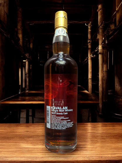 Flasche Kavalan Solist Brandy Single Malt Whisky vor einem dunkelgrauen Hintergrund, hervorgehoben durch sanfte Beleuchtung, die die elegante Form und das leuchtend goldene Label betont.