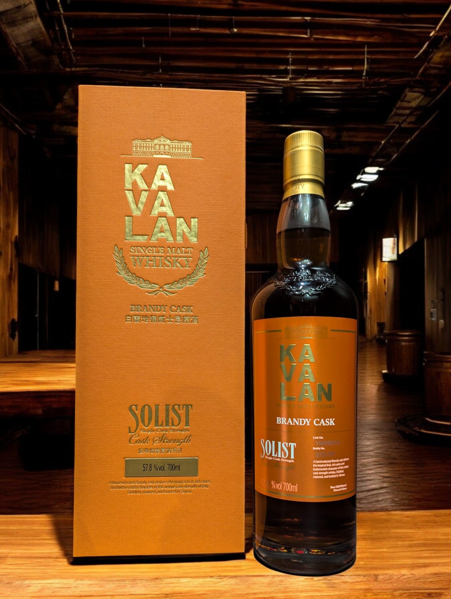 Flasche Kavalan Solist Brandy Single Malt Whisky vor einem dunkelgrauen Hintergrund, hervorgehoben durch sanfte Beleuchtung, die die elegante Form und das leuchtend goldene Label betont.