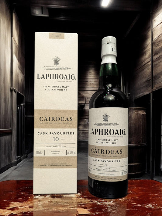 Eine Flasche Laphroaig Cairdeas 2024 Whisky auf Holztisch vor dunklem Hintergrund