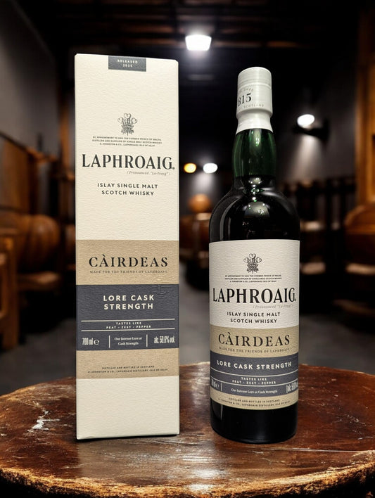 Eine Flasche Laphroaig Cairdeas 2025 Single Malt Whisky auf einem Holztisch vor dunklem Hintergrund
