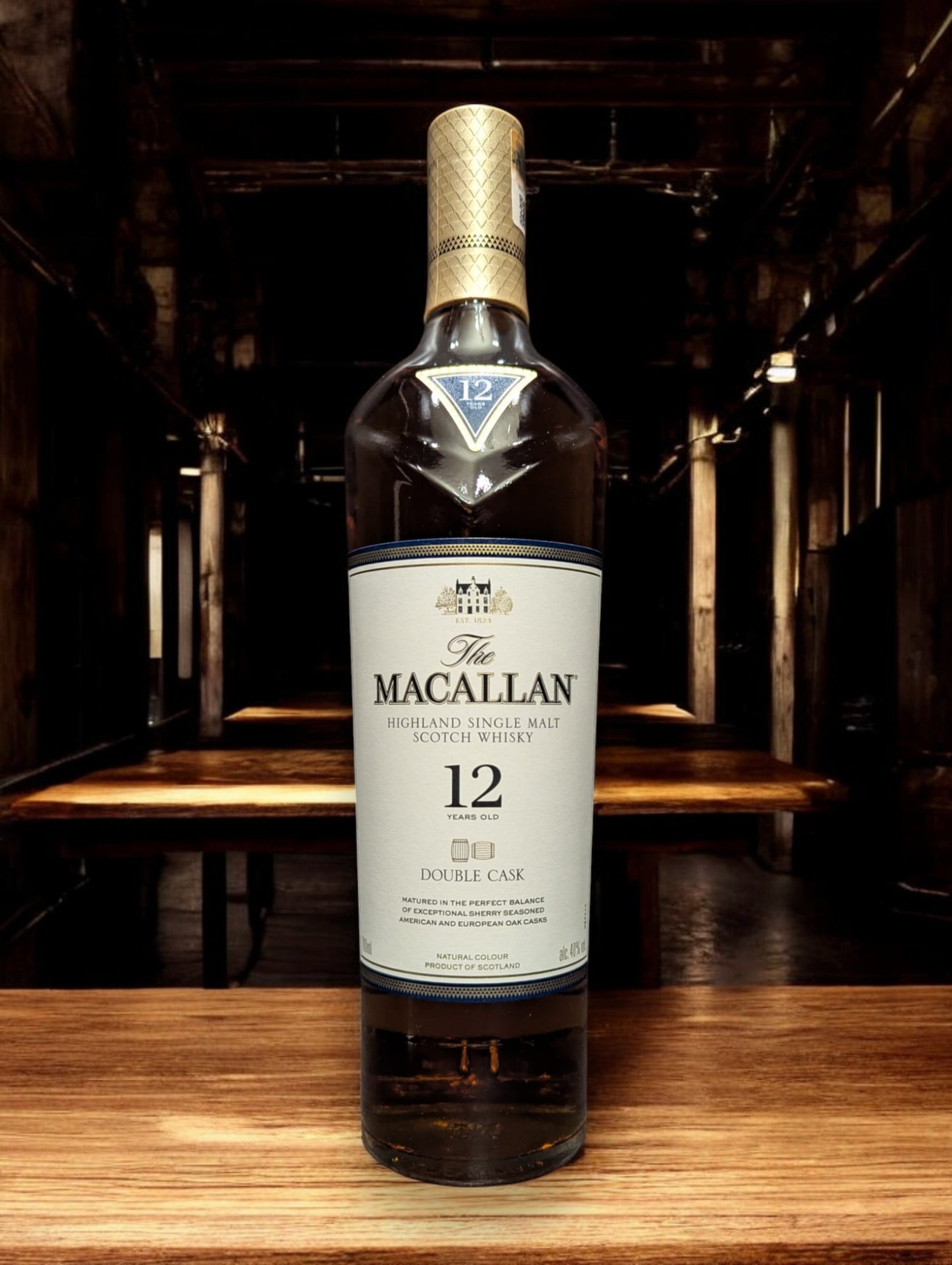 
Eine Flasche Macallan 12 Jahre Double Cask Whisky in einer eleganten Destilleriehalle mit polierten Holzfässern und gedämpfter Beleuchtung. Die luxuriöse Flasche mit ihrem goldenen Etikett und der klaren Schrift strahlt Exklusivität aus und fügt sich perfekt in die raffinierte, traditionelle Atmosphäre ein, die den Reifeprozess in amerikanischen und europäischen Eichenfässern widerspiegelt.