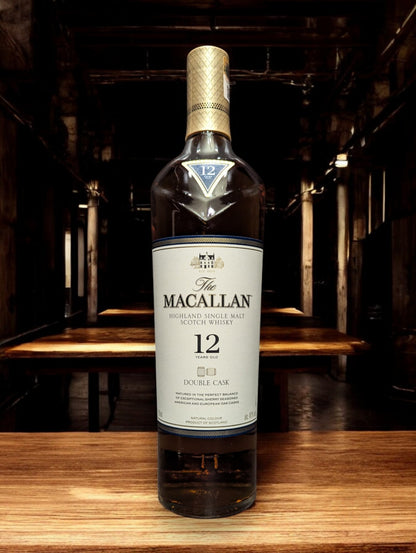 
Eine Flasche Macallan 12 Jahre Double Cask Whisky in einer eleganten Destilleriehalle mit polierten Holzfässern und gedämpfter Beleuchtung. Die luxuriöse Flasche mit ihrem goldenen Etikett und der klaren Schrift strahlt Exklusivität aus und fügt sich perfekt in die raffinierte, traditionelle Atmosphäre ein, die den Reifeprozess in amerikanischen und europäischen Eichenfässern widerspiegelt.