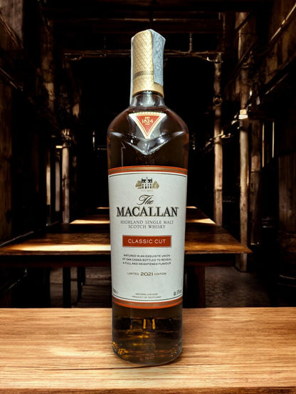 Elegante Flasche des Macallan Classic Cut 2021 Whisky, hervorgehoben durch ein stilvolles Etikett, das die Meisterschaft der Fasskunst reflektiert, mit einem warmen, tiefgoldenen Whisky-Ton, der sichtbar durch das Glas scheint, vor einem Hintergrund, der Luxus und handwerkliche Perfektion suggeriert.
