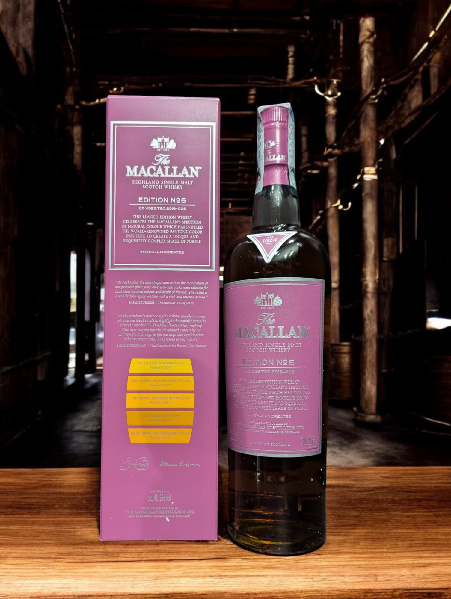 Eine Flasche von The Macallan Edition No. 5, kunstvoll inszeniert gegen einen einfachen Hintergrund, um die Bedeutung der natürlichen Farbe des Whiskys zu betonen. Das lebendige, lila Etikett und die Verpackung feiern die Farbpalette, die in der Whiskyherstellung ohne zusätzliche Farbstoffe entsteht, und ehren so die Reinheit und Ästhetik des Destillats.