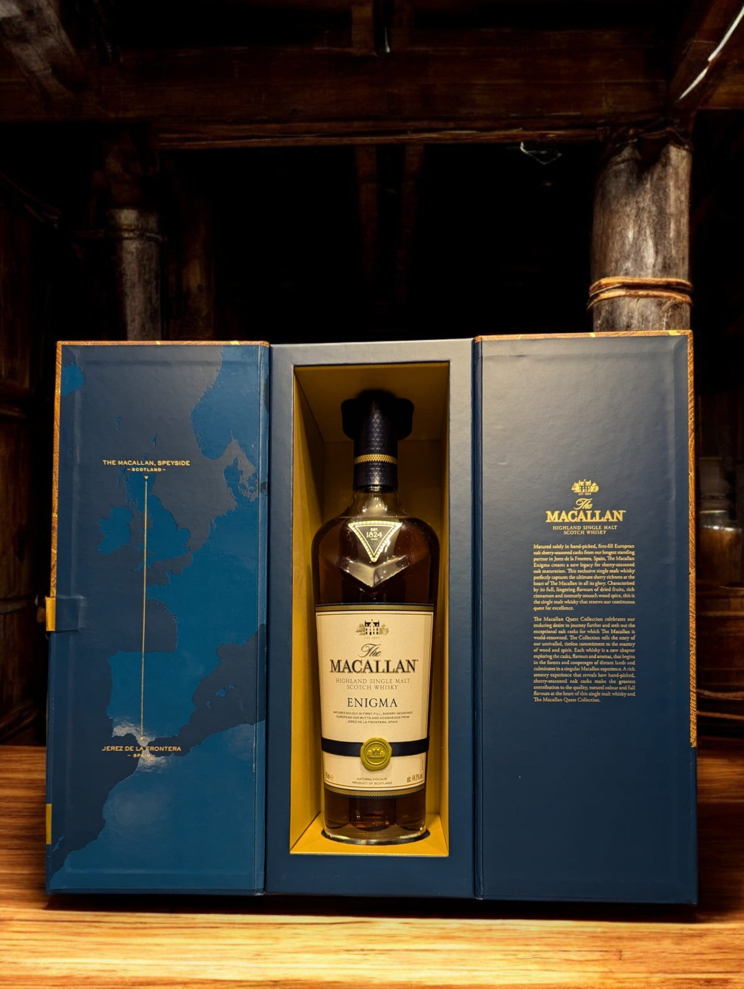 Flasche Macallan Enigma aus der Quest Collection, präsentiert vor einem dunkelgrauen Hintergrund, mit einem intensiven, rötlich-braunen Farbton des Whiskys, der durch das Glas schimmert, und einem auffälligen Etikett, das die Exklusivität und Rätselhaftigkeit dieser Abfüllung unterstreicht