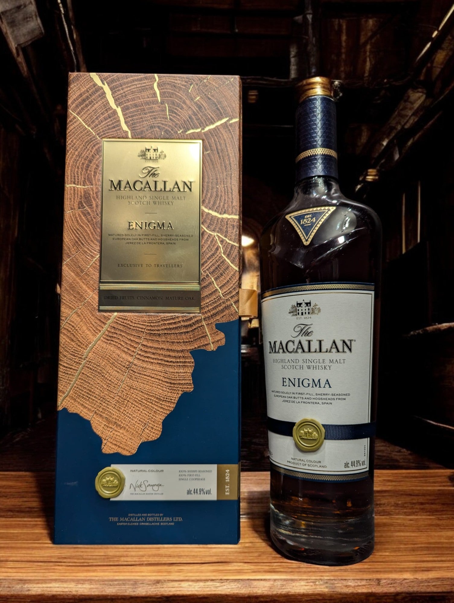Flasche Macallan Enigma aus der Quest Collection, präsentiert vor einem dunkelgrauen Hintergrund, mit einem intensiven, rötlich-braunen Farbton des Whiskys, der durch das Glas schimmert, und einem auffälligen Etikett, das die Exklusivität und Rätselhaftigkeit dieser Abfüllung unterstreicht