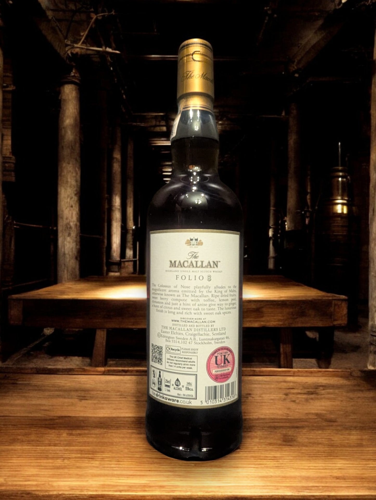Flasche Macallan Folio 8 Single Malt Whisky vor dem atmosphärischen Hintergrund der dunklen Macallan-Destillerie, betont Eleganz und Tradition.