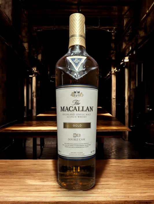 Flasche Macallan Gold Whisky präsentiert sich vor einem dunkelgrauen Hintergrund, wobei das warme, bernsteinfarbene Leuchten des Whiskys und das markante Etikett im Fokus stehen.