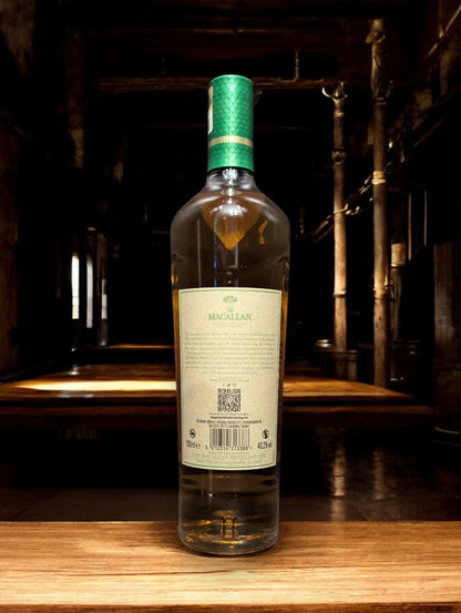 Flasche Macallan Harmony Collection Green Meadow Single Malt Whisky vor einem dunkelgrauen Hintergrund, mit einem subtilen Schimmer, der die grünlichen Akzente auf der Flasche und das hochwertige Etikett akzentuiert.