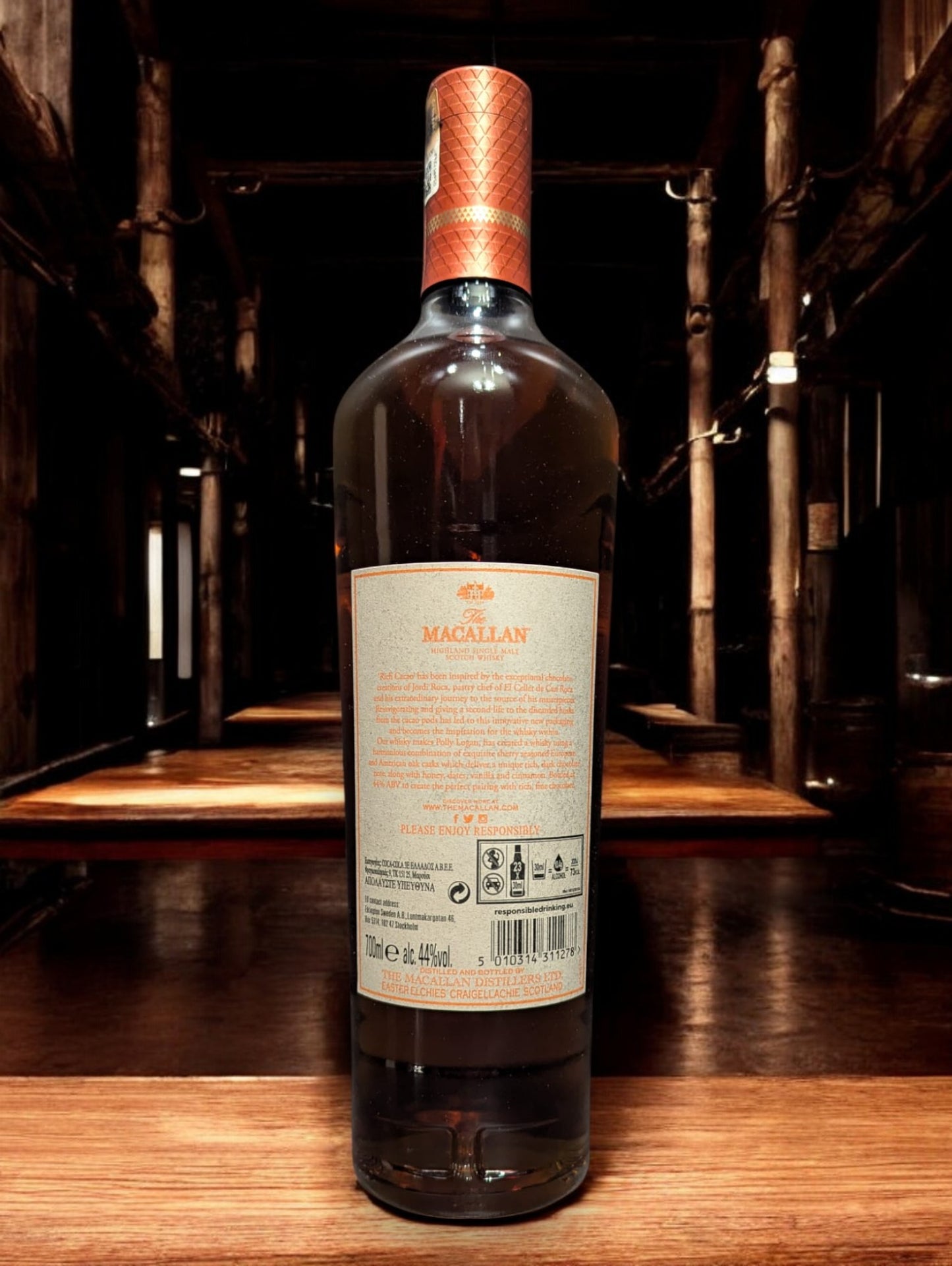 Flasche Macallan Harmony Collection Rich Cacao Whisky, präsentiert vor einem dunklen Hintergrund, mit einem dezenten Glanz, der die luxuriöse, dunkelbraune Farbgebung des Whiskys und das stilvolle, schokoladenfarbene Etikett unterstreicht.