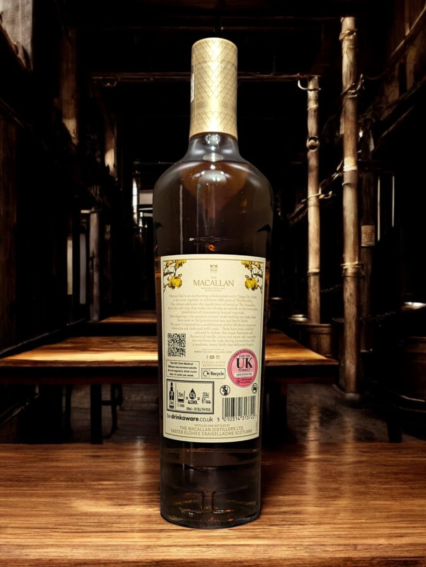 Flasche des Macallan Harmony Collection Vibrant Oak Single Malt Whisky steht vor einem dunklen Hintergrund, wobei das warme, goldene Amber des Whiskys betont wird und das elegante, helle Eichenholzfarbene Etikett ins Auge fällt.