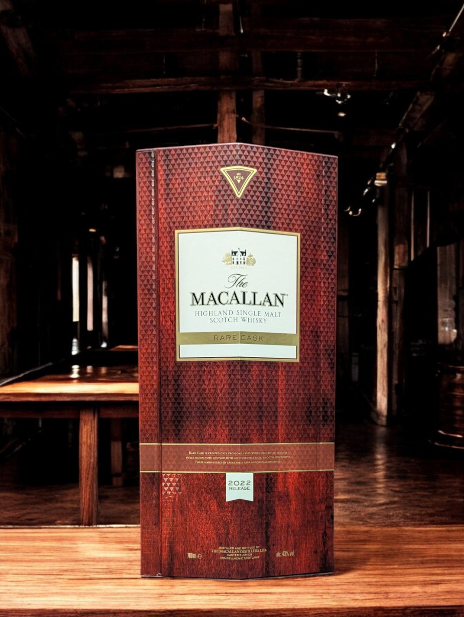 Exquisite Flasche Macallan Rare Cask 2022, sorgfältig platziert vor einem dunkelgrauen Hintergrund, was die reiche, rubinrote Farbe des Whiskys hervorhebt. Die Flasche zeichnet sich durch ihr luxuriöses Design aus, mit einem auffälligen, schwarz-goldenen Etikett, das die Seltenheit und Exklusivität dieses herausragenden Jahrgangs unterstreicht.