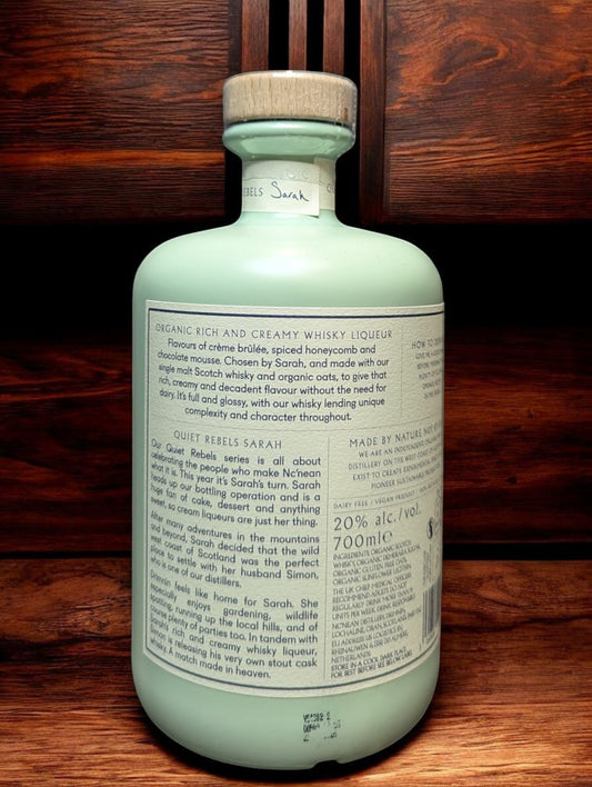Flasche Nc'Nean Whiskylikör - Quiet Rebels Sarah vor dunklem Hintergrund aus den Highlands