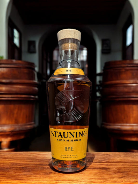Flasche Stauning Rye auf einem Tisch vor Fässern