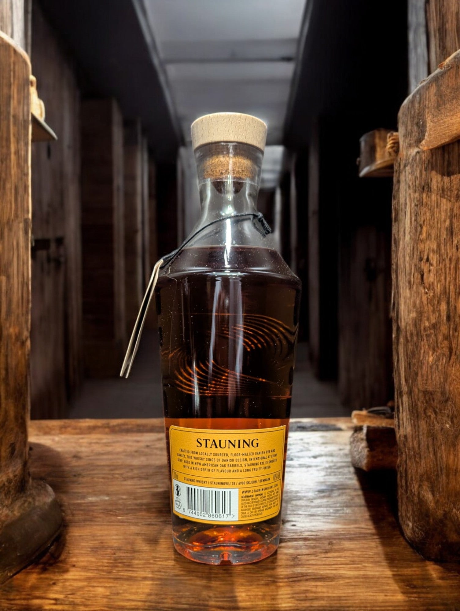 Flasche Stauning Rye auf einem Tisch vor Fässern