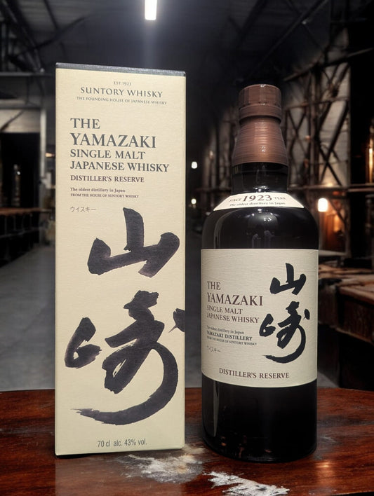 Eine Flasche Yamazaki Distiller Reserve vor dunklem Hintergrund mit Distillenequipment für Whisky