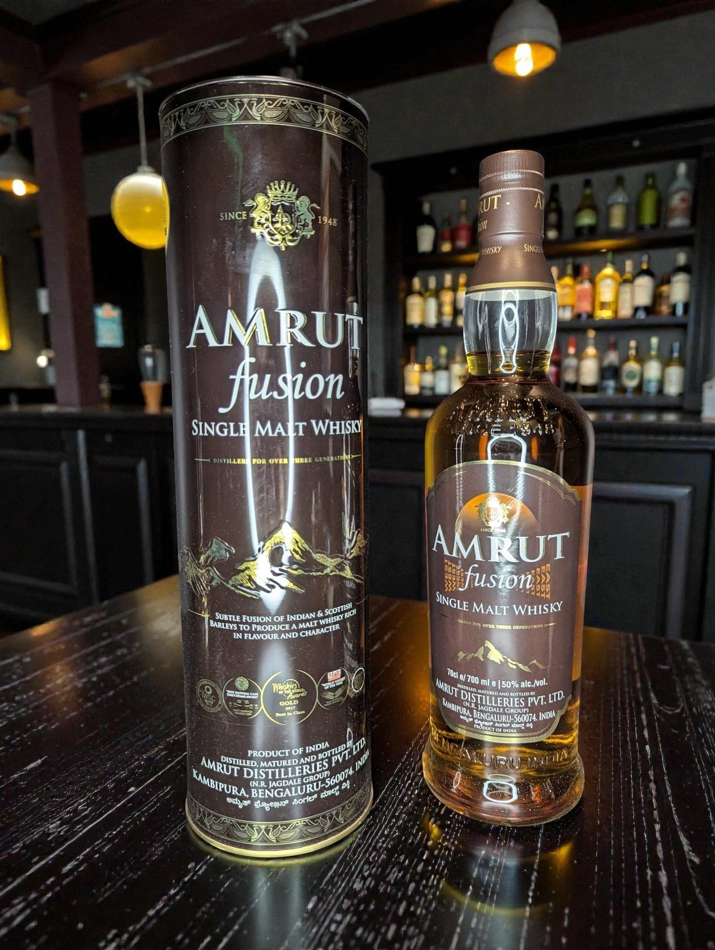 Whiskyquartier Amrut Fusion Single Malt Whisky 0.7L mit kräftigem Bernstein und goldenen Reflexen, Aroma von tropischen Früchten, Malz, Eiche und Torfrauch.