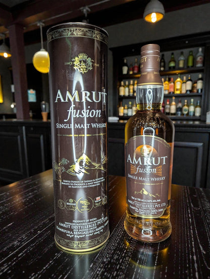 Whiskyquartier Amrut Fusion Single Malt Whisky 0.7L mit kräftigem Bernstein und goldenen Reflexen, Aroma von tropischen Früchten, Malz, Eiche und Torfrauch.