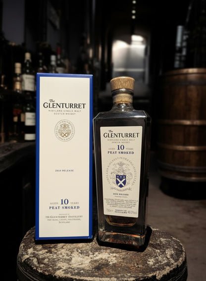 Glenturret 10 Years Peat Smoked 2025 Highland Single Malt Scotch Whisky in einer Glasflasche mit Holzkorken und passender blauer Kartonverpackung.