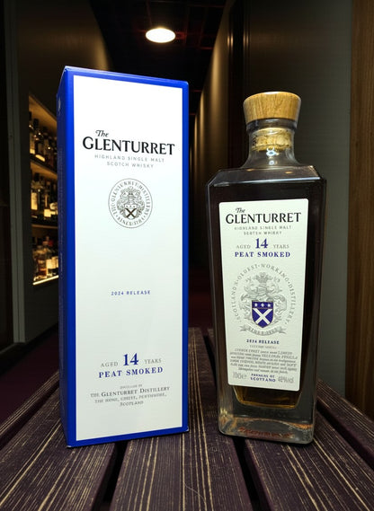 Glenturret 14 Years Peat Smoked 2024 Highland Single Malt Scotch Whisky in Glasflasche mit Holzkorken und blauer Kartonverpackung.