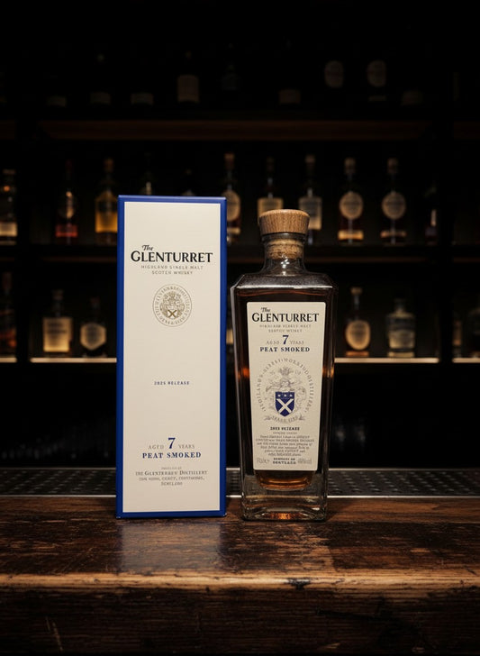 Glenturret 7 Years Peat Smoked 2025 Highland Single Malt Scotch Whisky in einer Glasflasche mit Holzkorken neben der blauen Kartonverpackung.