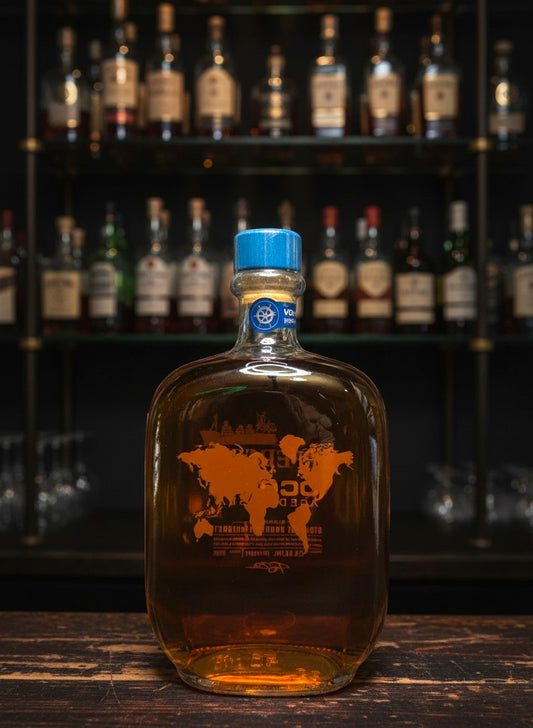 Whiskyquartier Jefferson's Ocean Aged at Sea Bourbon 0,7L Flasche mit Weltkarte und blauem Verschluss, umgeben von Fässern.