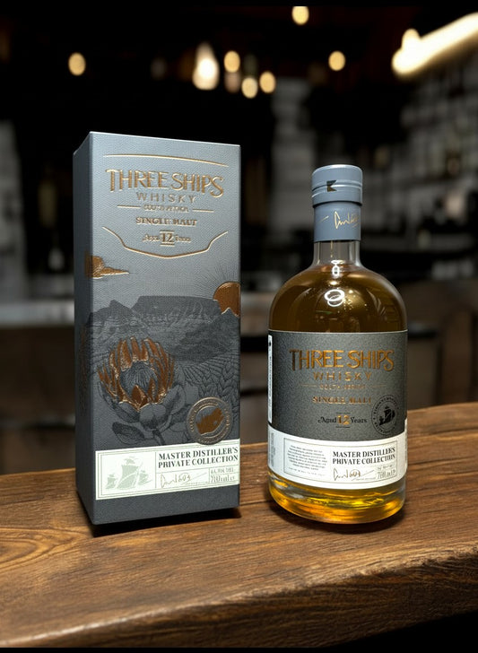 Three Ships 12 YO Master Distiller's Collection Single Malt Whisky in bernsteinfarbener Flüssigkeit mit kupfernen Reflexen, 0,7L Flasche und passender Geschenkbox.